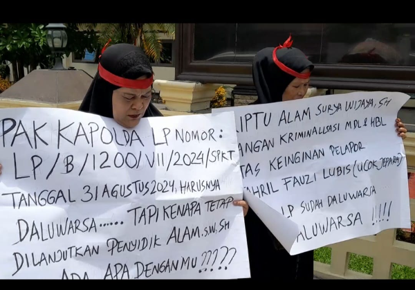 Fhoto  : Emak-emak yang mengaku jadi korban kriminalisasi membawa sejumlah poster di depan Mapolrestabes Medan, Rabu (3/9)*